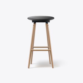 Wooden stool with black round seat.
